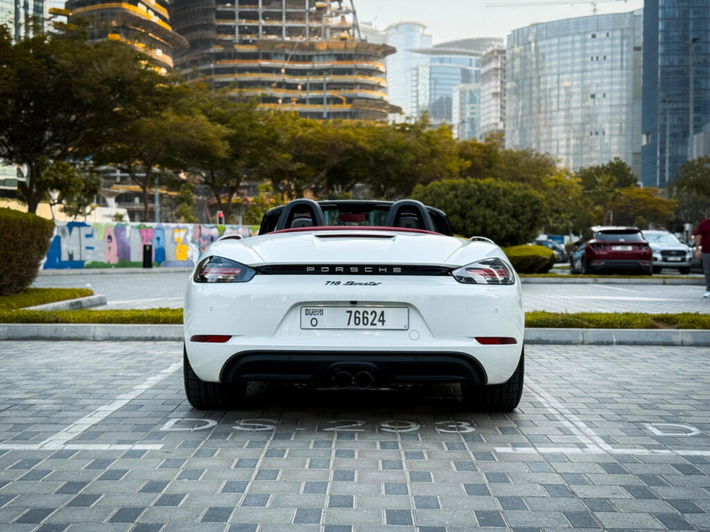 Rear view of a Porsche 718 Boxster convertible with the roof down on a Dubai street